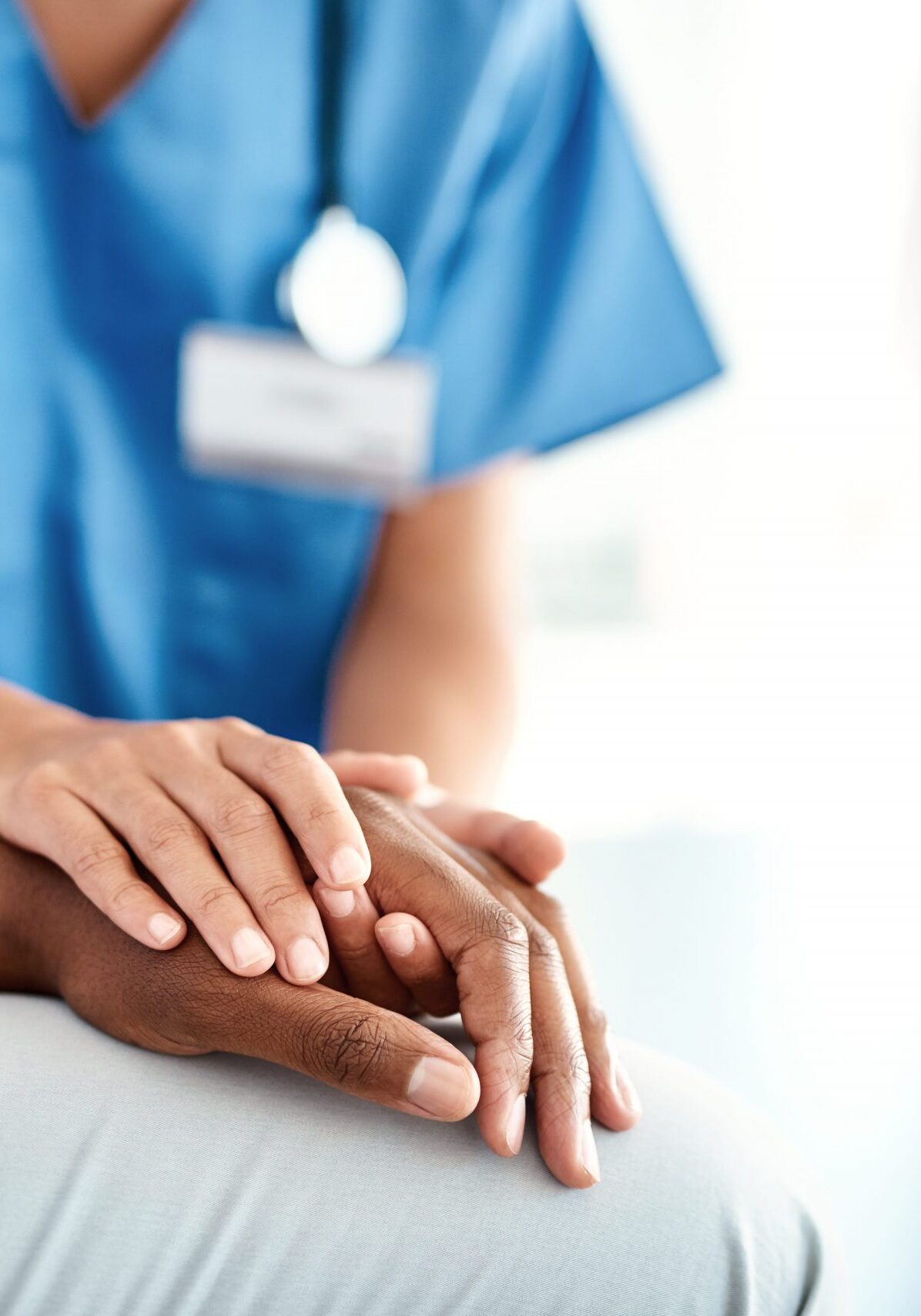 Nurse holding the hands of a patient